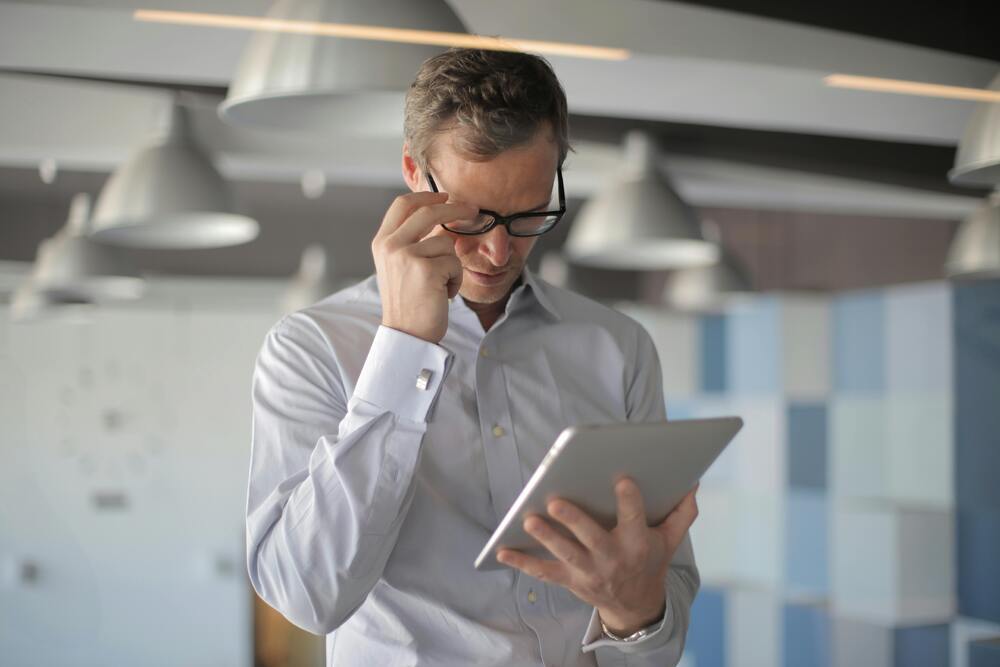 Man looking closely at information on tablet